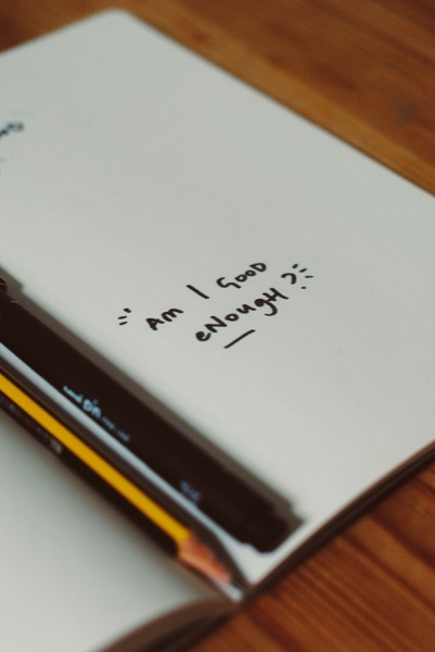 Notebook with handwritten question 'Am I good enough?'
