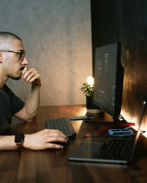 Man at desk in warm lighting looking at screen